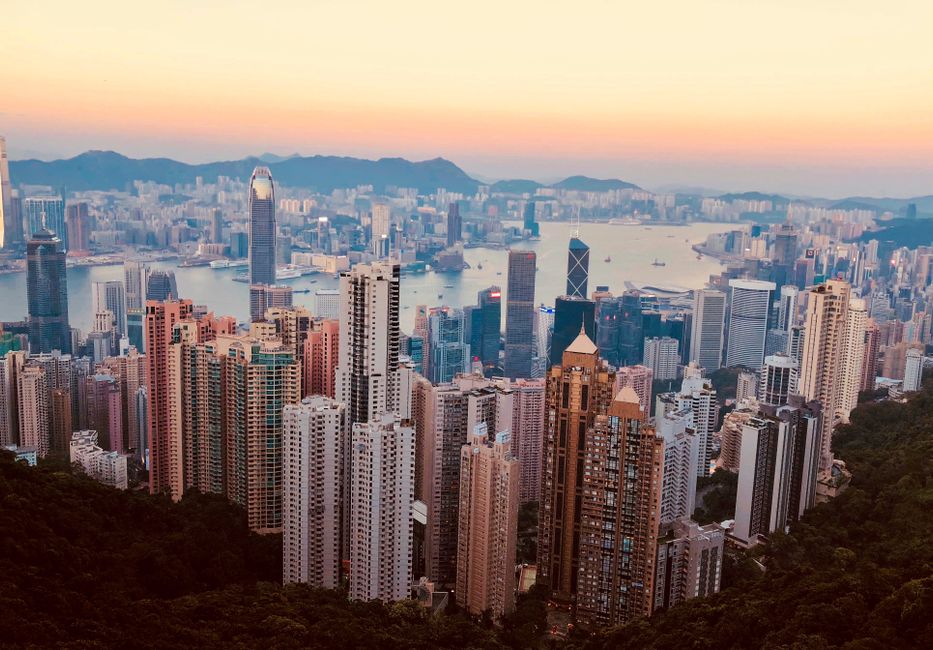Breathtaking Kowloon skyline with skyscrapers and harbor at sunset, showcasing Hong Kong's urban beauty.